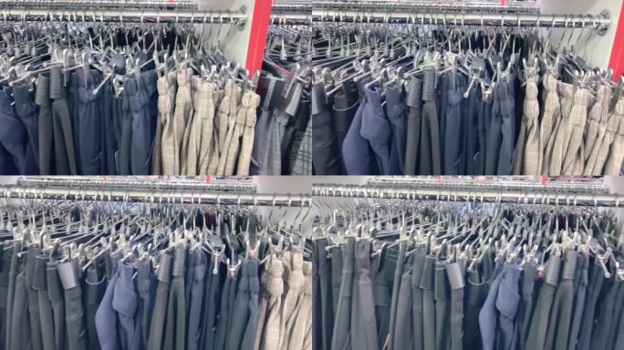 商店衣架上的灰色裤子，商店衣架上的衣服