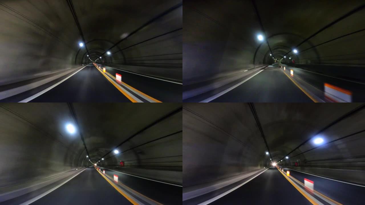 开车穿过高速公路隧道。隧道尽头的光