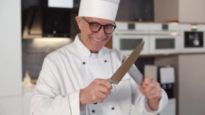 现代餐厅厨房里，两把刀对着镜头微笑的高级厨师