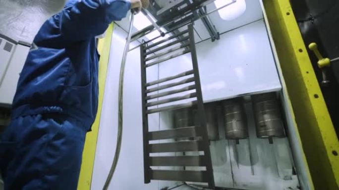 一名工人用喷枪喷涂不锈钢金属结构。干画法。