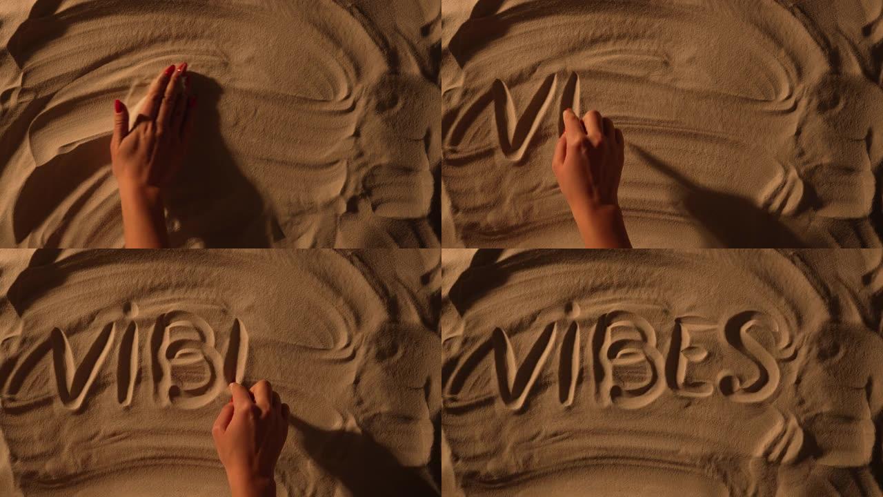 女性手平滑沙质表面并绘制铭文氛围。女性手的特写是在沙滩上画画。海边的暑假，享受海滩的假期。旅游旺季。