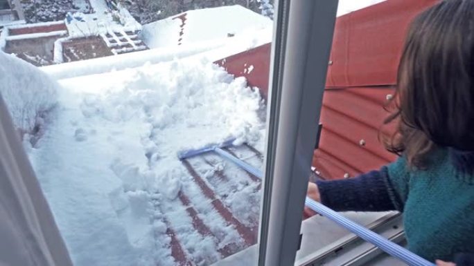 大雪后，女人在屋顶上除雪