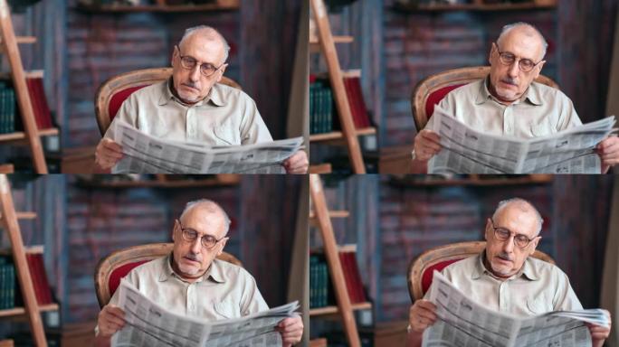 专注的老人阅读纸质报纸文本在乡村家庭室内的扶手椅上放松