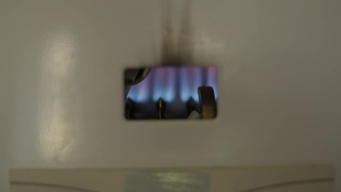 燃气热水器打开时，蓝色火焰点燃。室内天然化石燃料加热管的特写火焰。消费和家庭生活的概念。