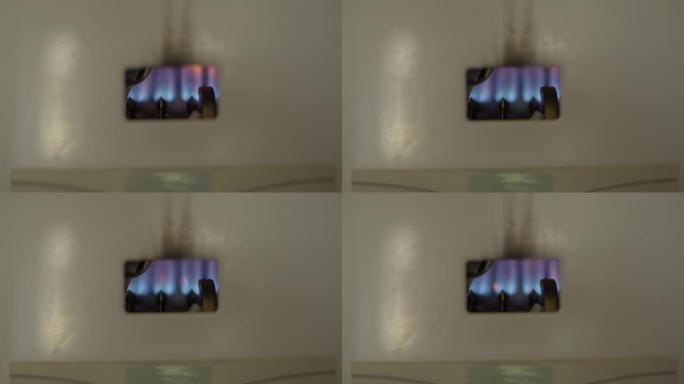 燃气热水器打开时，蓝色火焰点燃。室内天然化石燃料加热管的特写火焰。消费和家庭生活的概念。