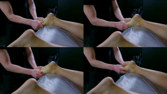 按摩师在水疗沙龙脱皮身体用天然磨砂膏擦洗女人的脚。