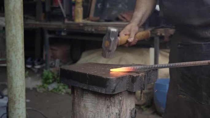 铁匠锻造铁匠铁砧锤人手动锻造熔融金属。