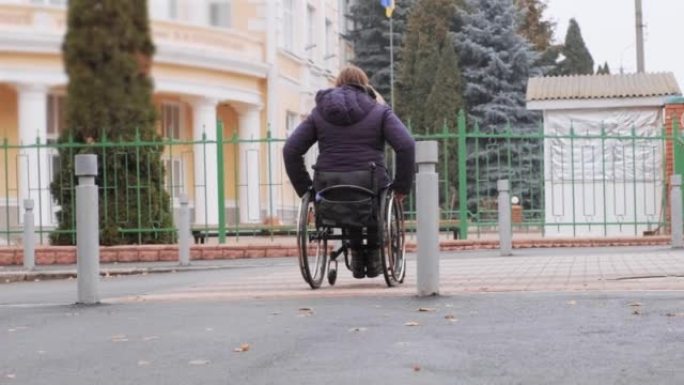 残疾人坐在轮椅上沿着街道移动，边境阻止轮椅移动