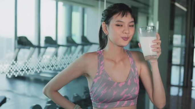 迷人的健身亚洲妇女完成锻炼和喝蛋白质牛奶奶昔维生素训练后。健美。健康的生活方式。