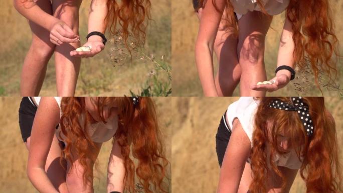 红发女孩走在海边阳光明媚的沙滩上