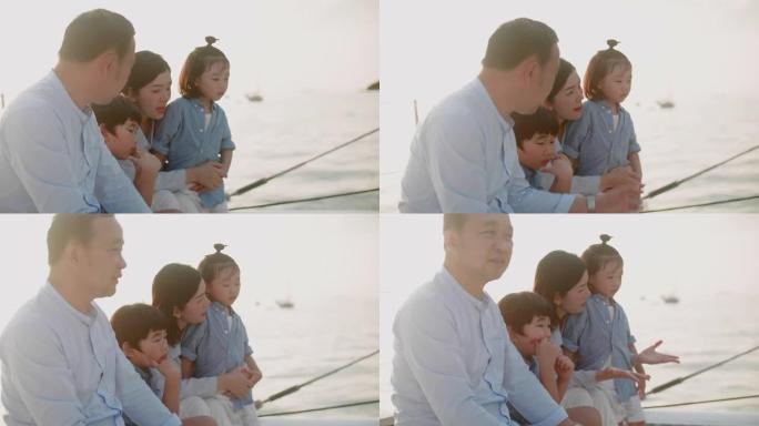 日落时在游艇上玩得开心的幸福家庭