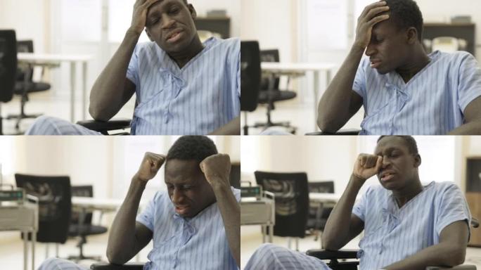 非洲族裔病人在医院坐轮椅头疼。