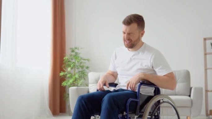 伤心的残疾人试图从轮椅上站起来，但没有成功。残疾人无法从轮椅上站起来，绝望地捶打着双腿