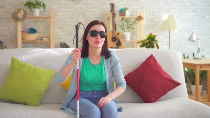 一个年轻的盲人残疾妇女的肖像与手杖盲人在现代公寓