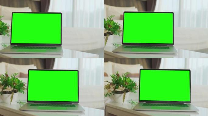 家庭内部床上绿屏显示的笔记本电脑。