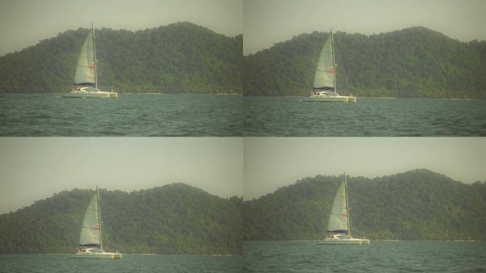 复古棕褐色温暖的景色。优美的帆船的慢动作镜头在蓝色的绿松石平静的海水中滑行。热带暑假。在开阔的海洋上