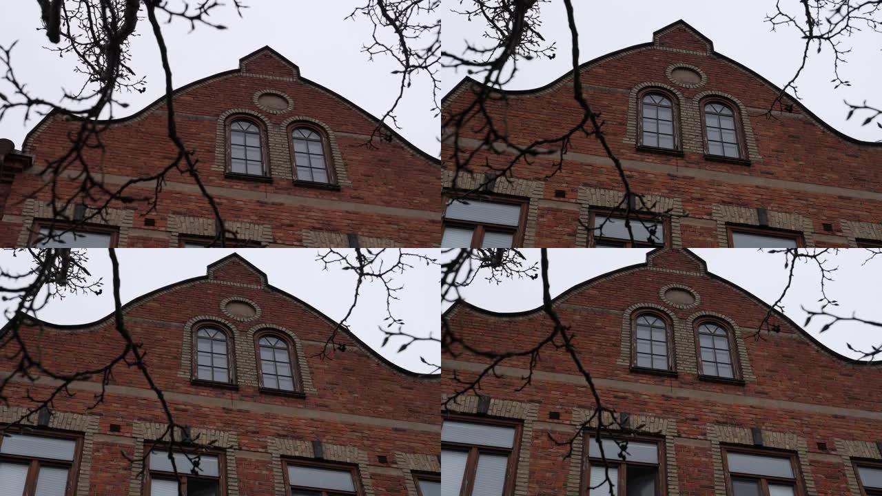 18世纪欧洲砖砌建筑外部和冬季树枝，手持