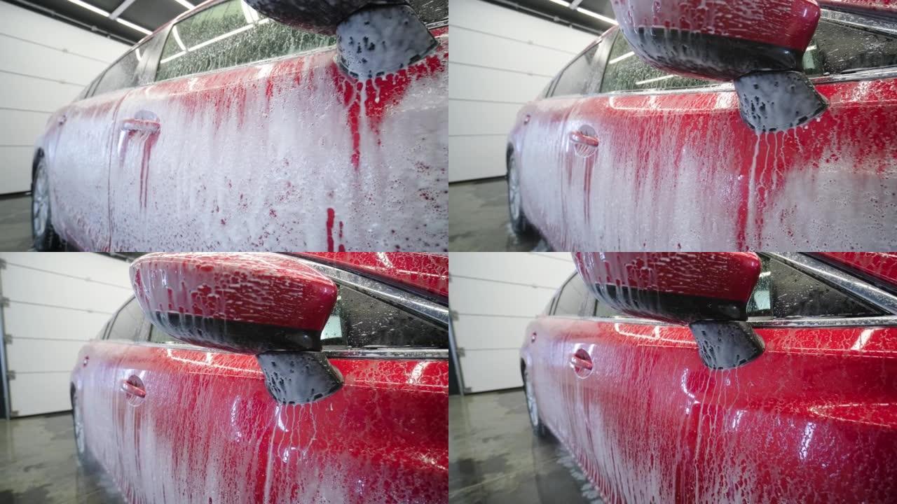 红色洗车用流动的水和泡沫。