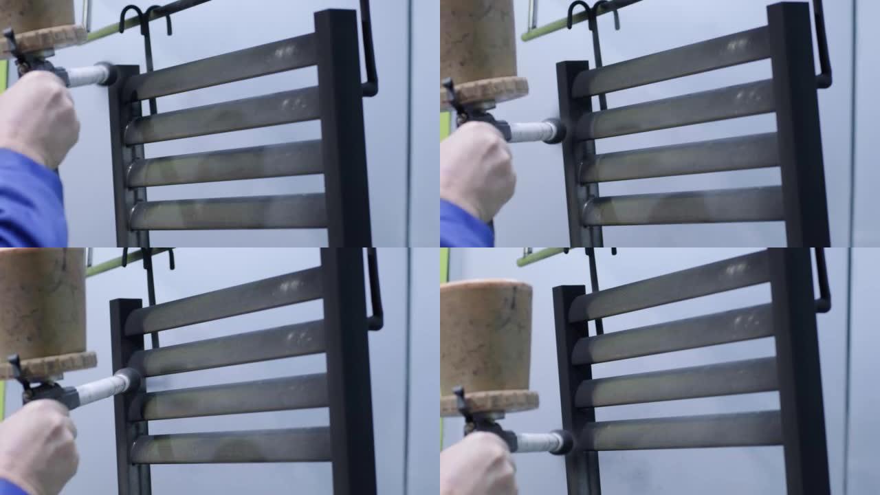 一名工人用喷枪喷涂不锈钢金属结构。干画法。
