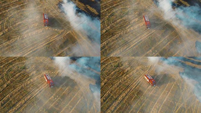 勇敢的消防员争先恐后地用烟雾和消防车与危险干燥的残茬在农艺领域扑灭燃烧的火焰