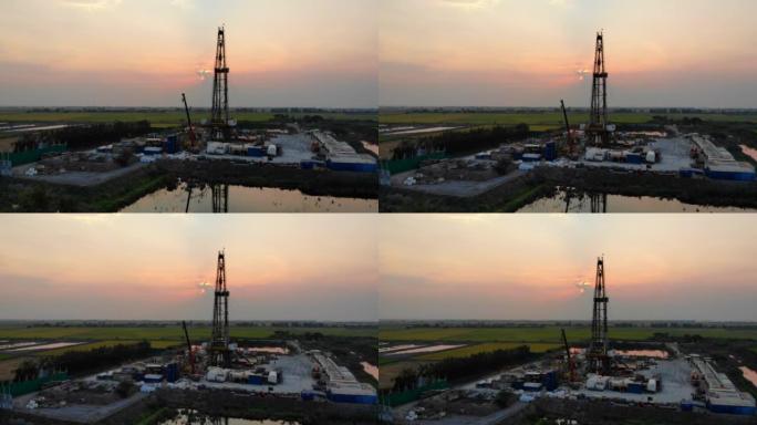 夕阳下的石油钻塔在稻田里