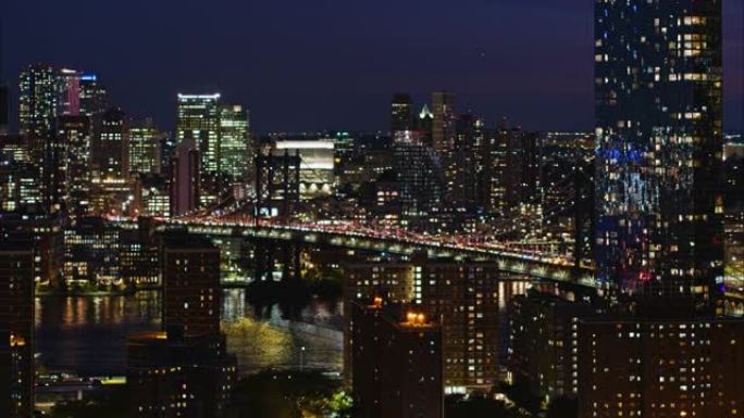 夜望纽约曼哈顿东河上的曼哈顿大桥。平移摄像机运动的航拍镜头。