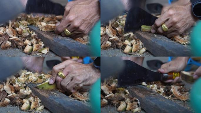 男人把椰子壳切成碎片。