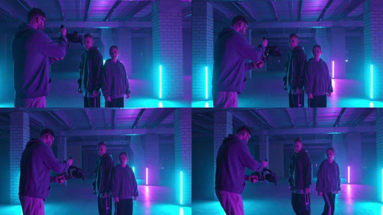 视频拍摄的后台。摄影师在霓虹灯下拍摄嘻哈舞者。操作员在黑暗工作室用手中的图像稳定器移动。拍摄剪辑