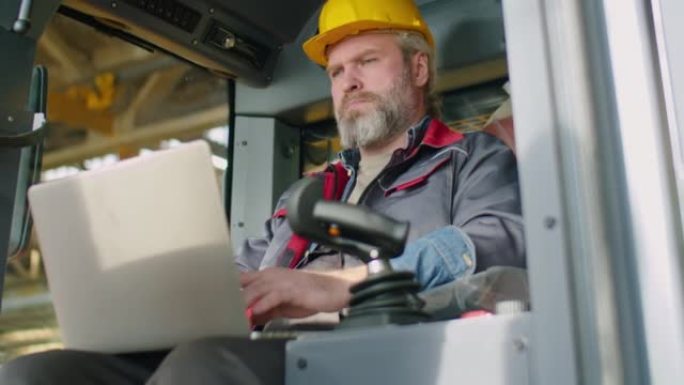 高级工厂技术员用笔记本电脑检查建筑机械