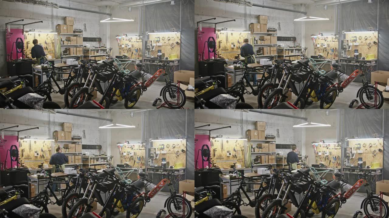 生产电动自行车的大型车间商务生态项目。一名男子在带有人工照明的大房间中，在大型电动自行车eco自行车