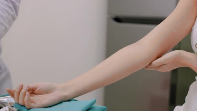 医生拿着注射器，为女性客户注射液体维生素，以增强免疫系统，促进新陈代谢，解决烧伤。美容美容师戴着手套