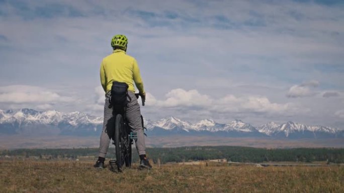 该名男子乘坐混合地形自行车旅行，并乘坐自行车旅行。旅行者带着自行车包旅行。体育旅游自行车包装