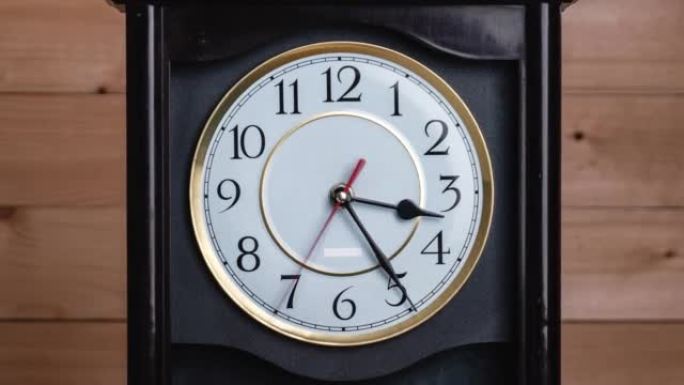 木制背景上时间指针移动的老式时钟的延时