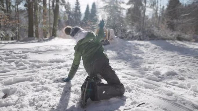 两个男孩在阳光明媚的冬日玩打雪仗。
