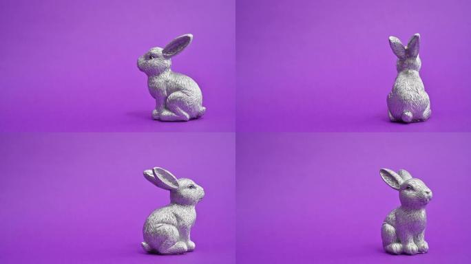 陶瓷银色复活节兔子在充满活力的紫色背景上旋转。停止运动