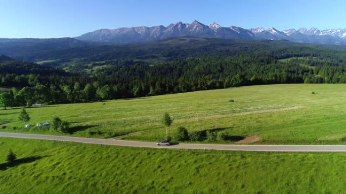 在空旷的道路上行驶的山路和豪华轿车的鸟瞰图。在大塔特拉山脉的背景下。概念: 山区度假，家庭公路旅行，