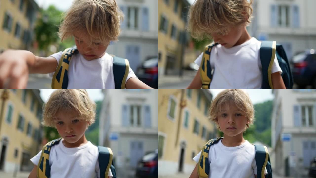 小男孩在街上背着背包走在外面