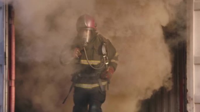 消防员从火中冒出的烟雾中着火了。