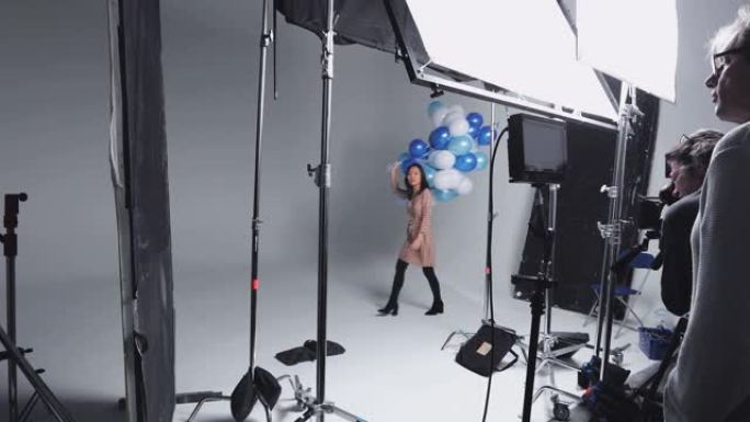 工作室拍摄摄影师用一堆气球拍摄女孩