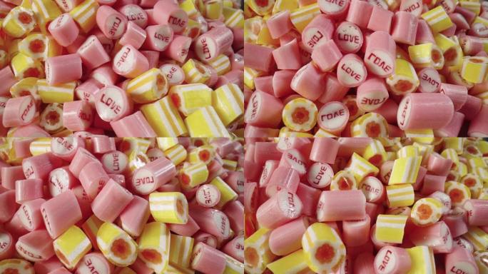 彩色条纹焦糖糖果什锦，旋转镜头。粉色和黄色棒棒糖的混合特写。甜糖甜点。糖果店。节日背景。慢动作就绪，