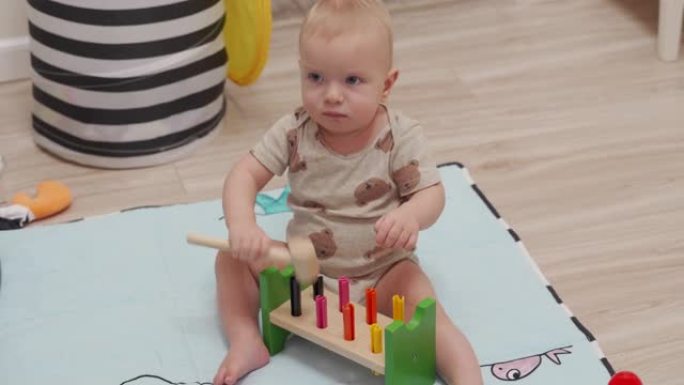可爱的小孩玩木制玩具锤击积木玩具，10个月大的高加索男婴在家玩地板。幼儿教育玩具。