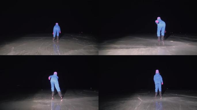 孩子在冰上速滑训练。夜间滑冰。这个女孩在冬天穿着运动服和运动眼镜滑冰。户外慢动作
