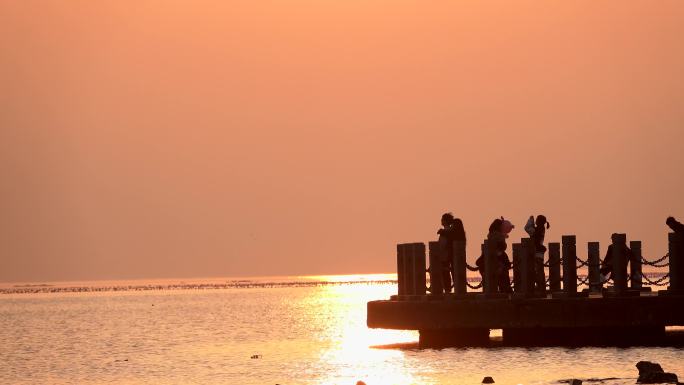 夕阳大海，栈桥上的年轻人们，情侣