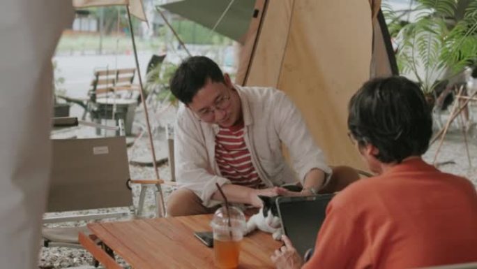 亚洲男子和退休妈妈一起在露营咖啡馆度过周末。