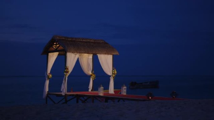 为海边设立的婚礼海滩。印度洋岸边用鲜花装饰的婚礼拱门。假日概念。日落时的婚礼活动图案岛