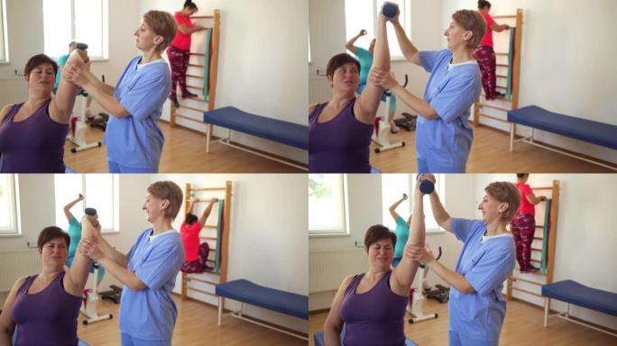 一名物理治疗师在康复过程中将一名妇女的手臂向后拉在肩膀上