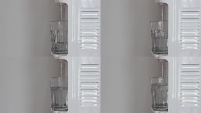 水从饮水机填充到透明玻璃