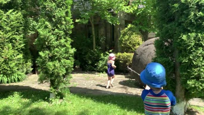 可爱快乐的孩子小学龄前女婴和男孩儿玩外面的水泵枪玩得开心。公园里阳光明媚炎热美好的一天。儿童后院花园