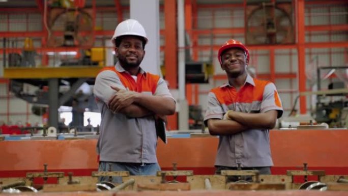 在工业工厂的生产线上做工程师、电工的工人，对工业标准充满信心地微笑着。
