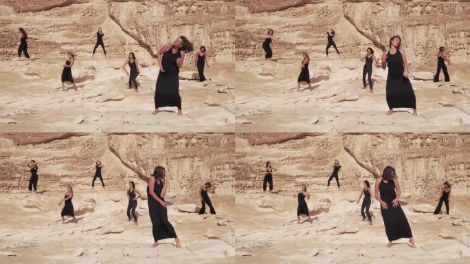 一群身着黑衣的妇女在沙漠峡谷中练习狂喜的舞蹈
